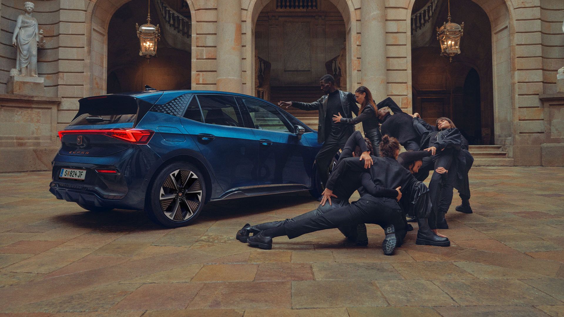 Eine Gruppe von Personen befindet sich neben einem blauen CUPRA Born.