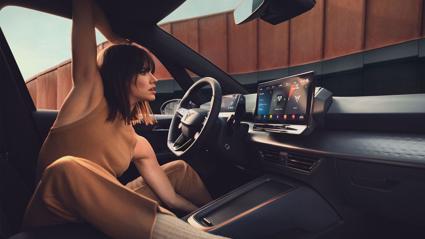 Eine Frau sitz am Fahrersitz eines CUPRA Born.