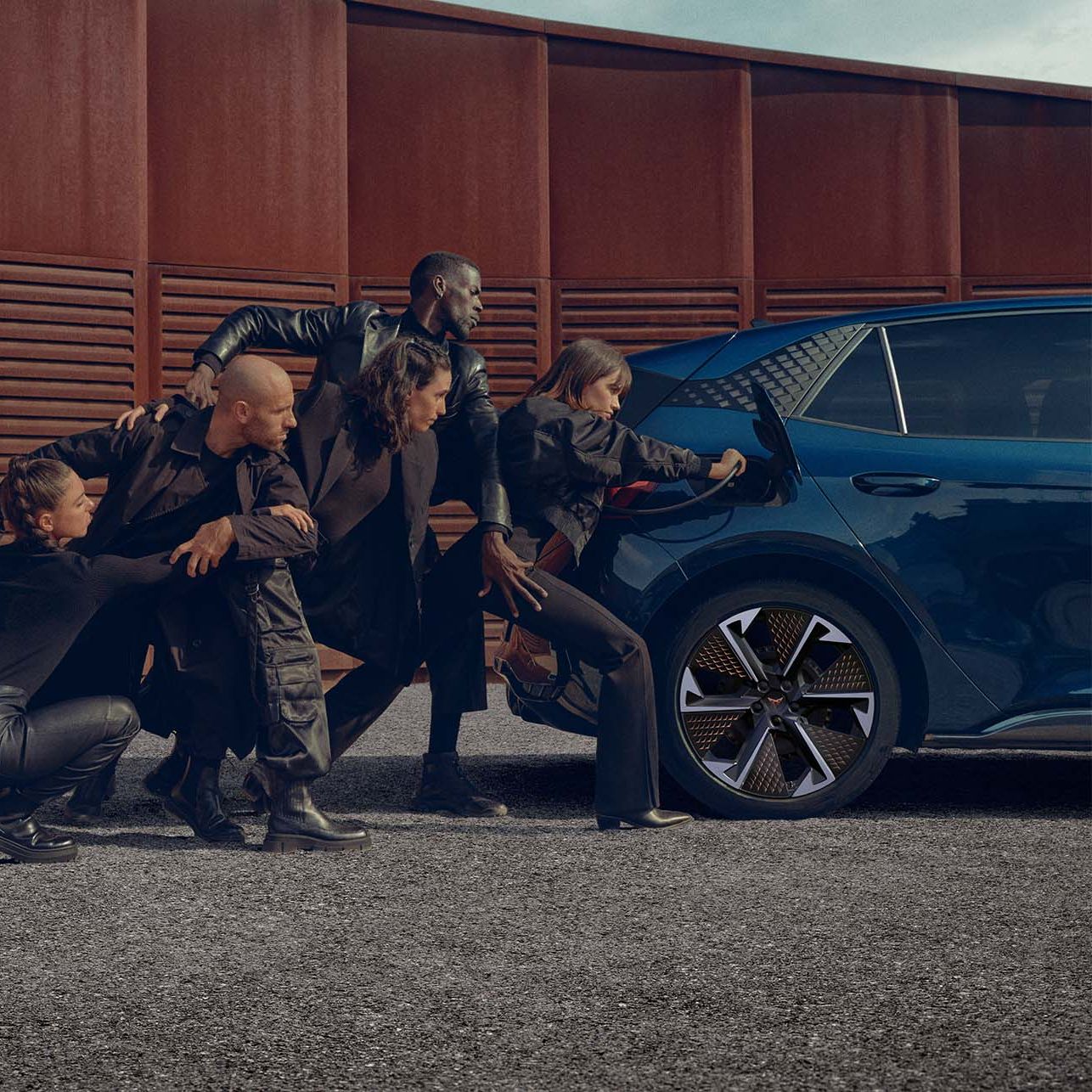 Eine Gruppe von Personen beim Aufladen eines blauen CUPRA Born an der Ladesäule.